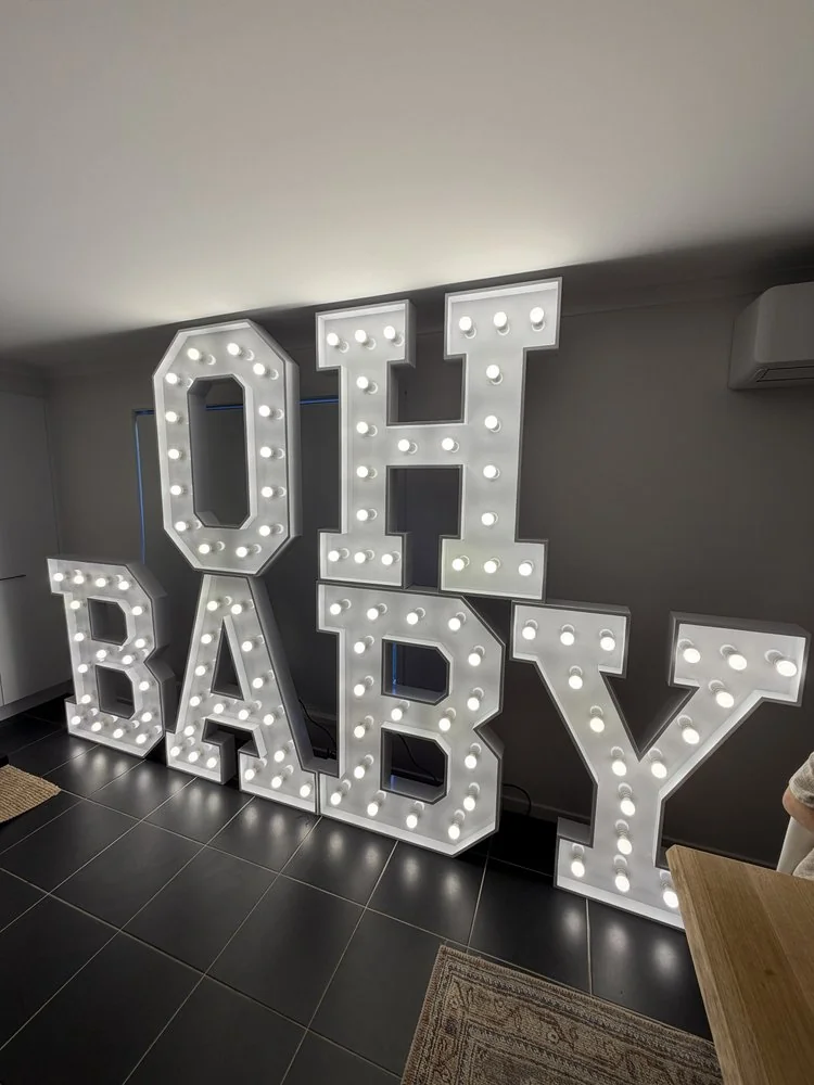 Illuminated OH BABY letters displayed indoors
