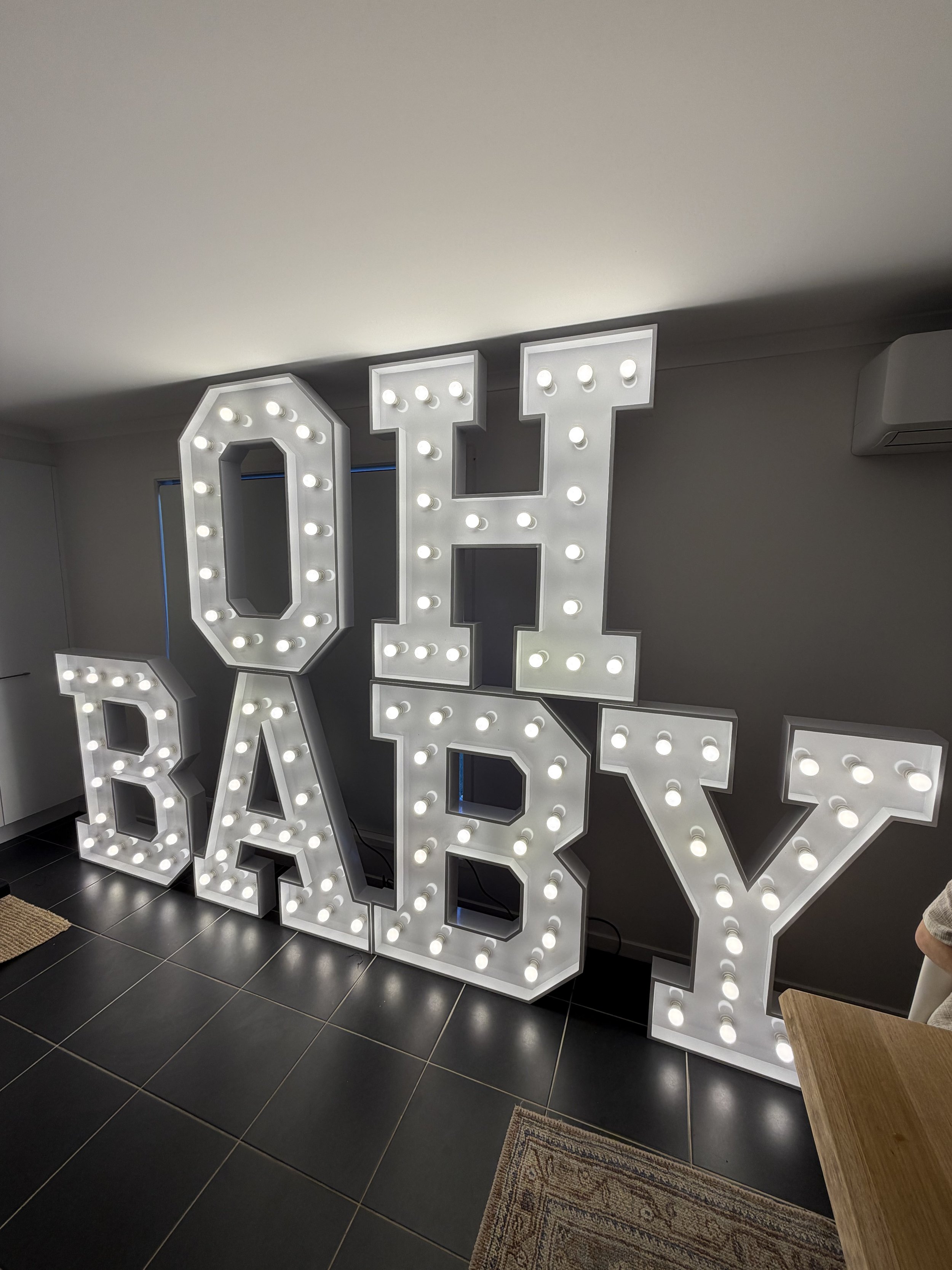 Illuminated OH BABY letters displayed indoors