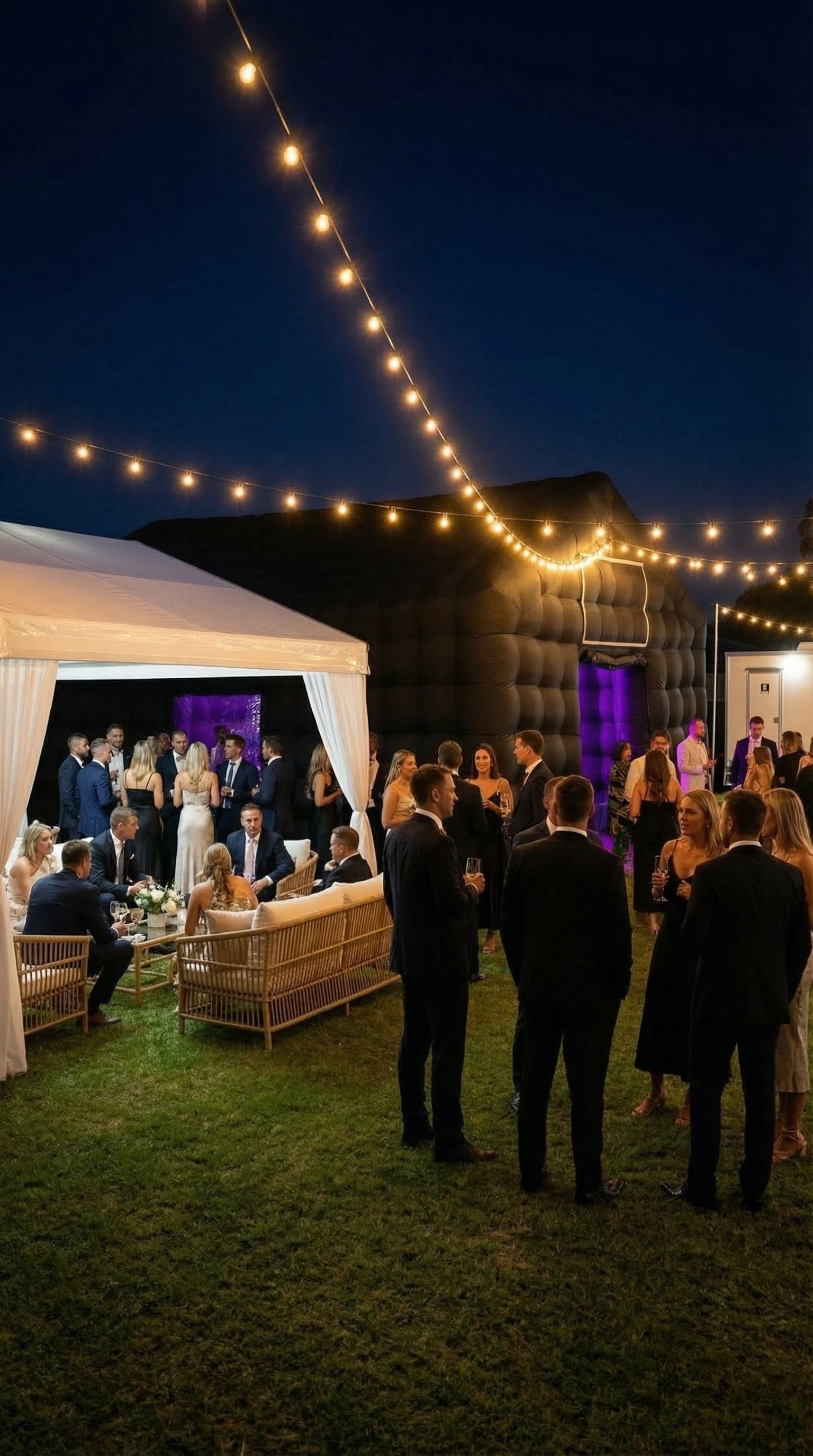 Guests beside the inflatable nightclub and festoon lights at night
