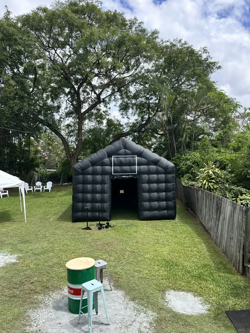 Cove inflatable nightclub positioned at the far end of a clear residential yard