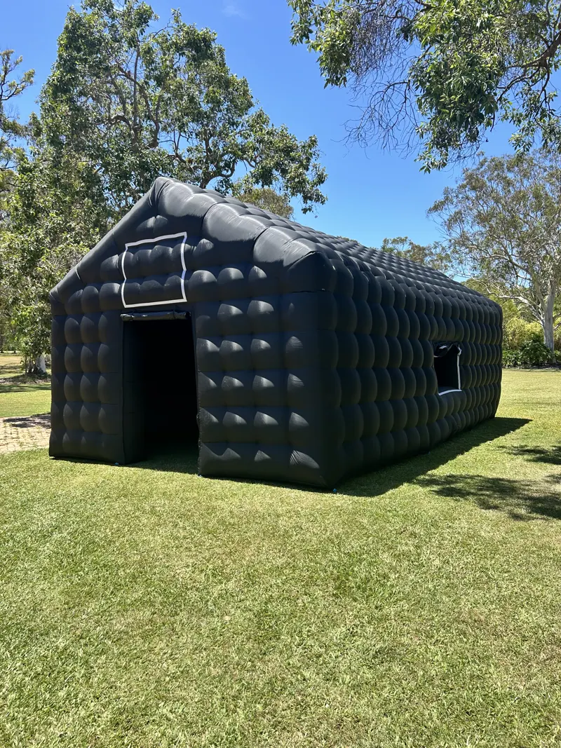 Side and front of Cove inflatable nightclub on a lawn beside trees