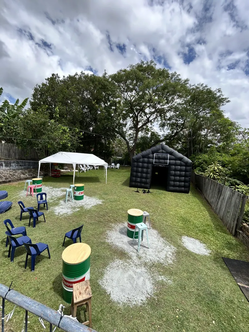 Wide view of a backyard party layout with Cove inflatable nightclub and seating